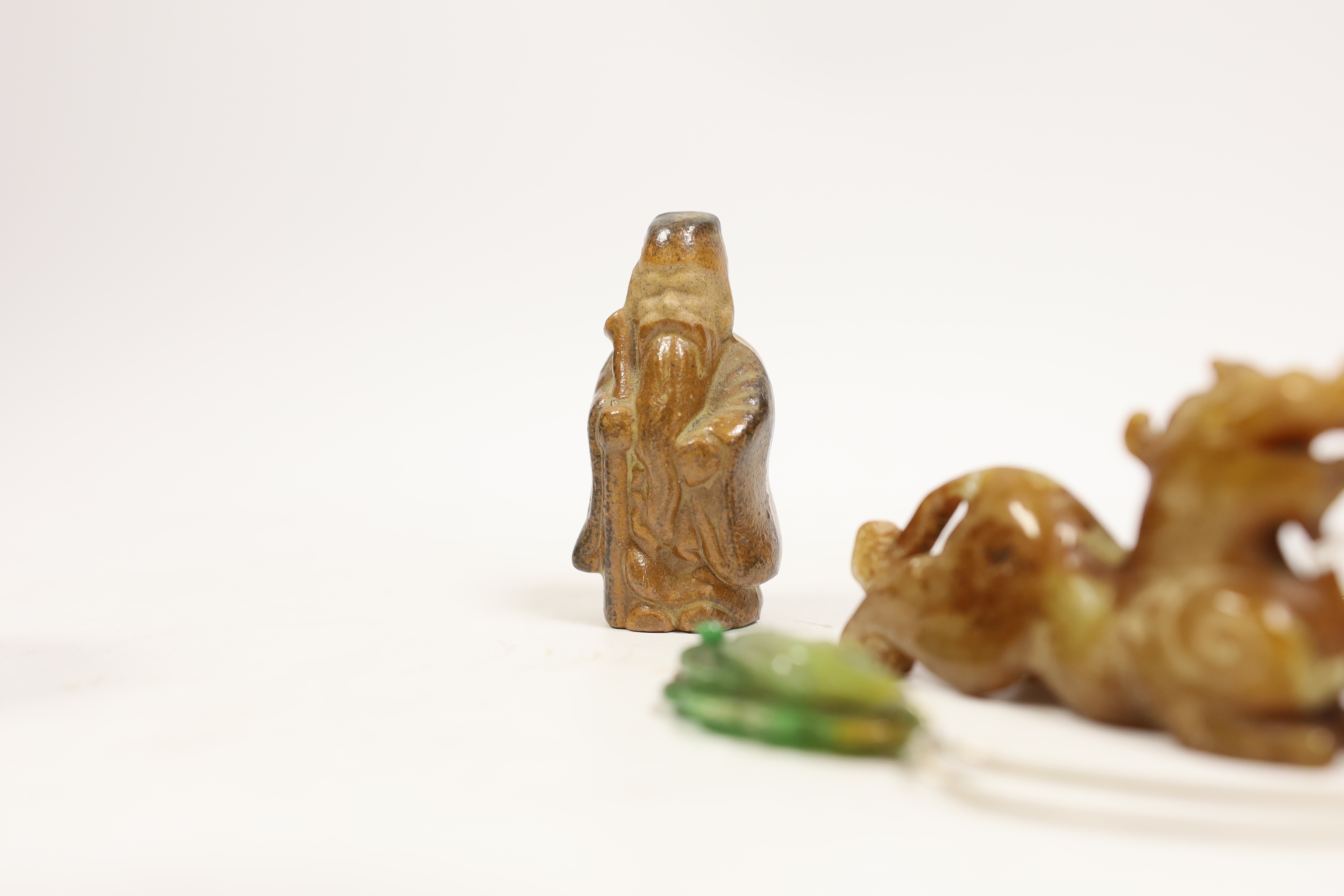 Six Chinese items including a carved jade fish pendant, a jade ring, a bowenite jade figure, an agate carved dragon, an earthenware miniature figure and a miniature carved stone bowl